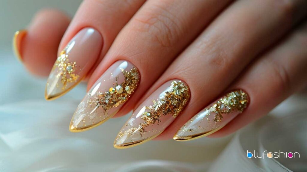 Elegant almond-shaped nails with beige base and sparkling gold gradient design.