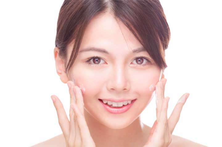 Asian beauty applying cream to face