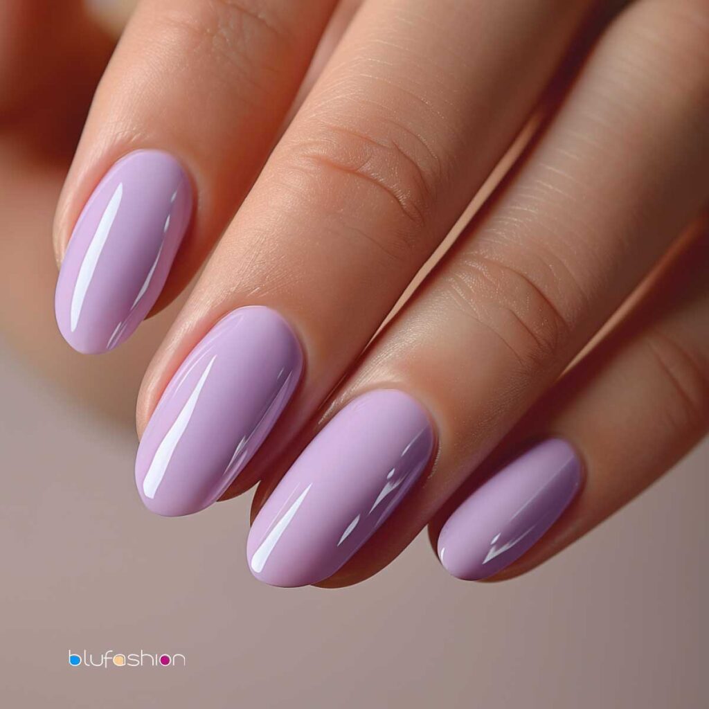 Close-up of hands with shiny pastel purple manicured nails in oval shape.