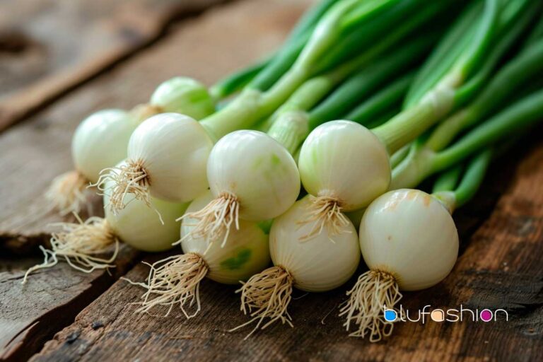 Bundle of fresh Cambray onions with green stems on wooden background by blufashion, healthy cooking ingredient