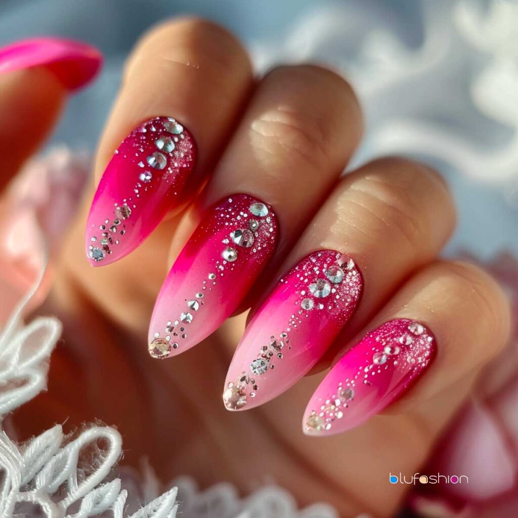 Gradient hot pink stiletto nails with a sparkling cascade of silver glitter and diamond rhinestones, creating a glamorous and eye-catching manicure.