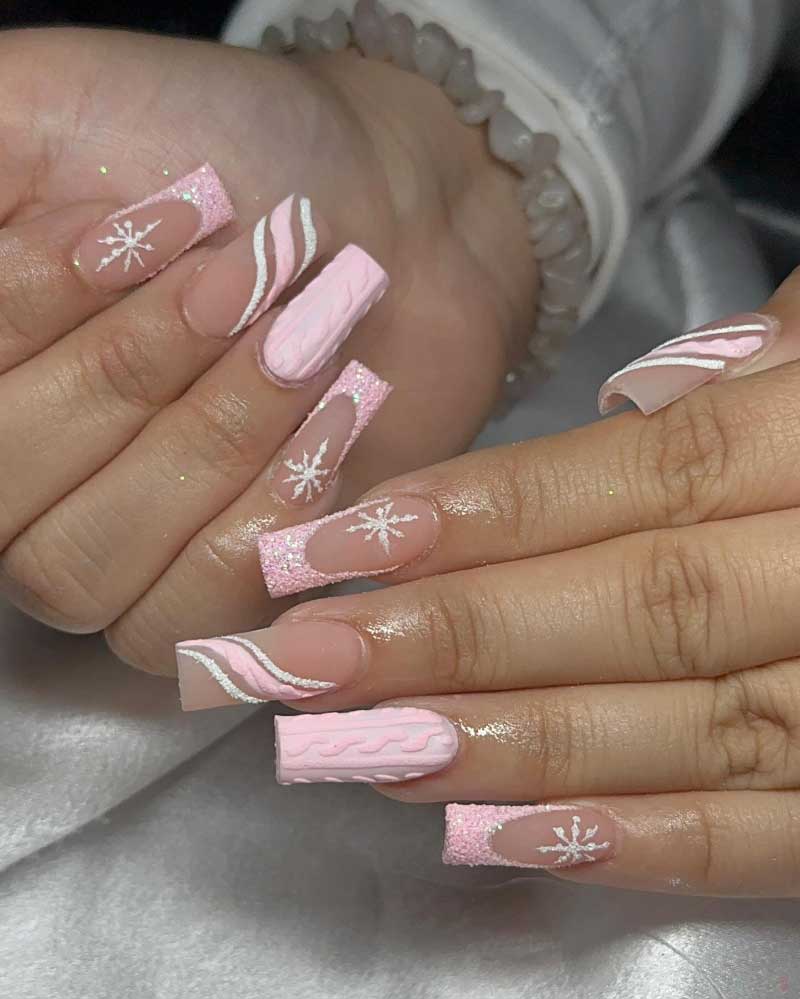 Sparkly pink winter nails with white cable knit pattern and delicate snowflake details.