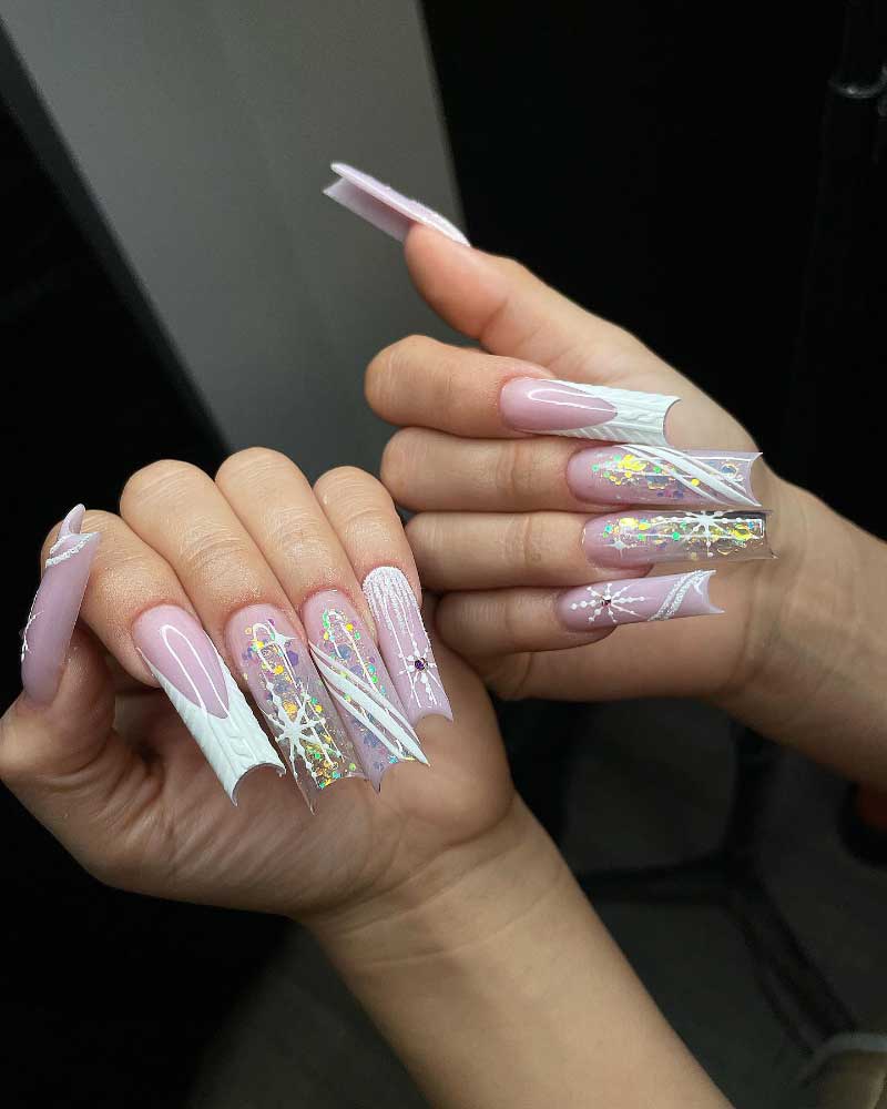 Long coffin nails with pink ombre, white knit patterns, and holographic glitter accents.