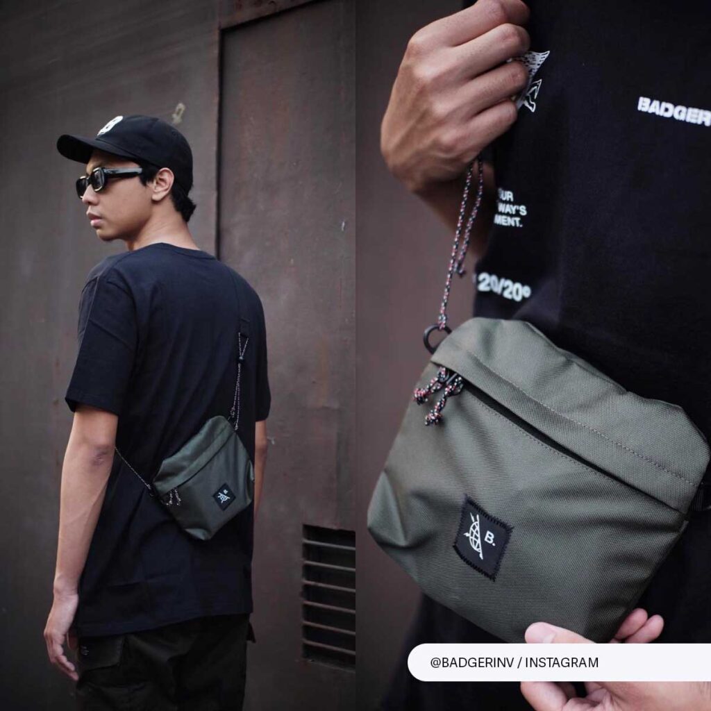 Man in urban streetwear with olive sling bag worn crossbody for a functional, trendy look.