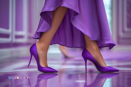 Elegant purple high heels matching with a flowing dress, perfect for a stylish event or wedding, reflected on a glossy floor.