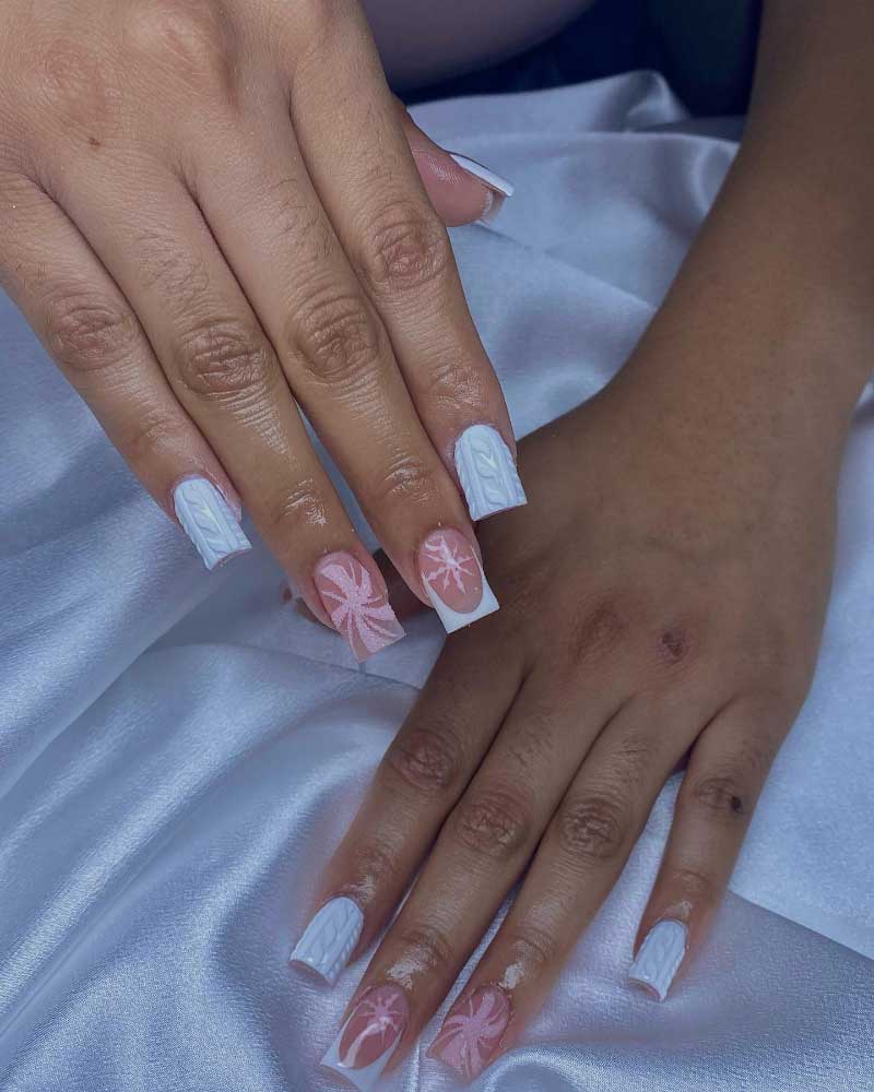 Chic white coffin nails with intricate pink snowflake and cable knit designs on satin.