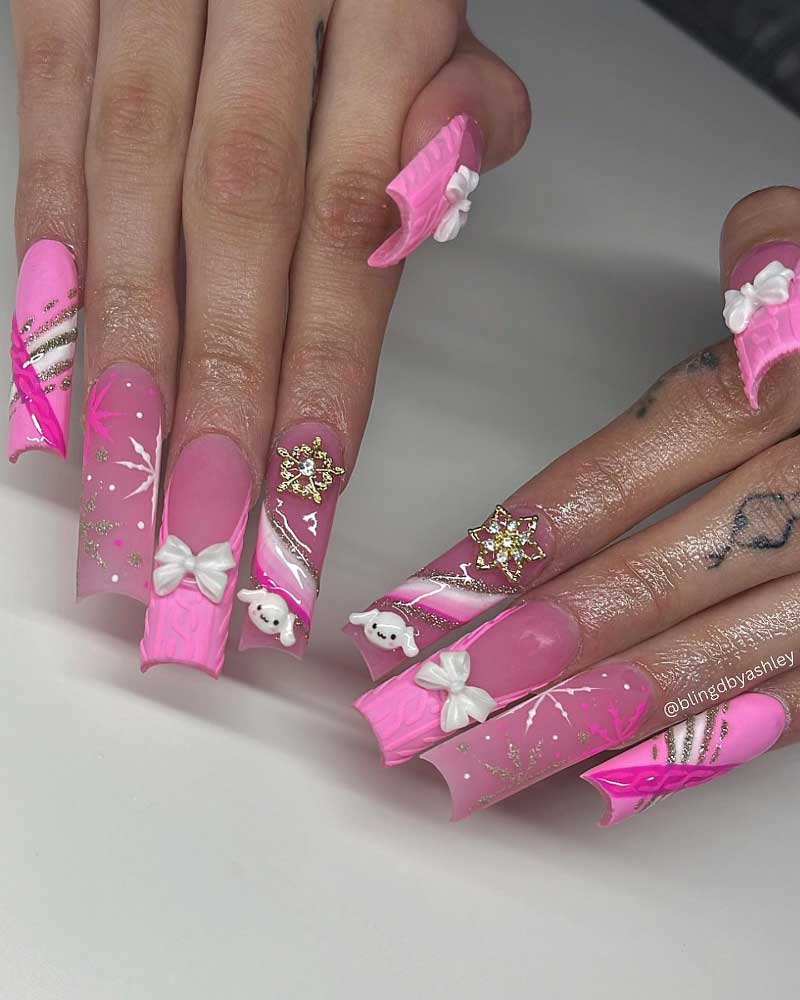 Extravagant pink stiletto nails with bows, gold flakes, and cute polar bear accents.